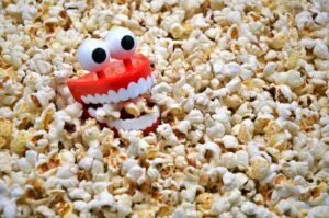 Toy teeth in a pile of popcorn looking happy